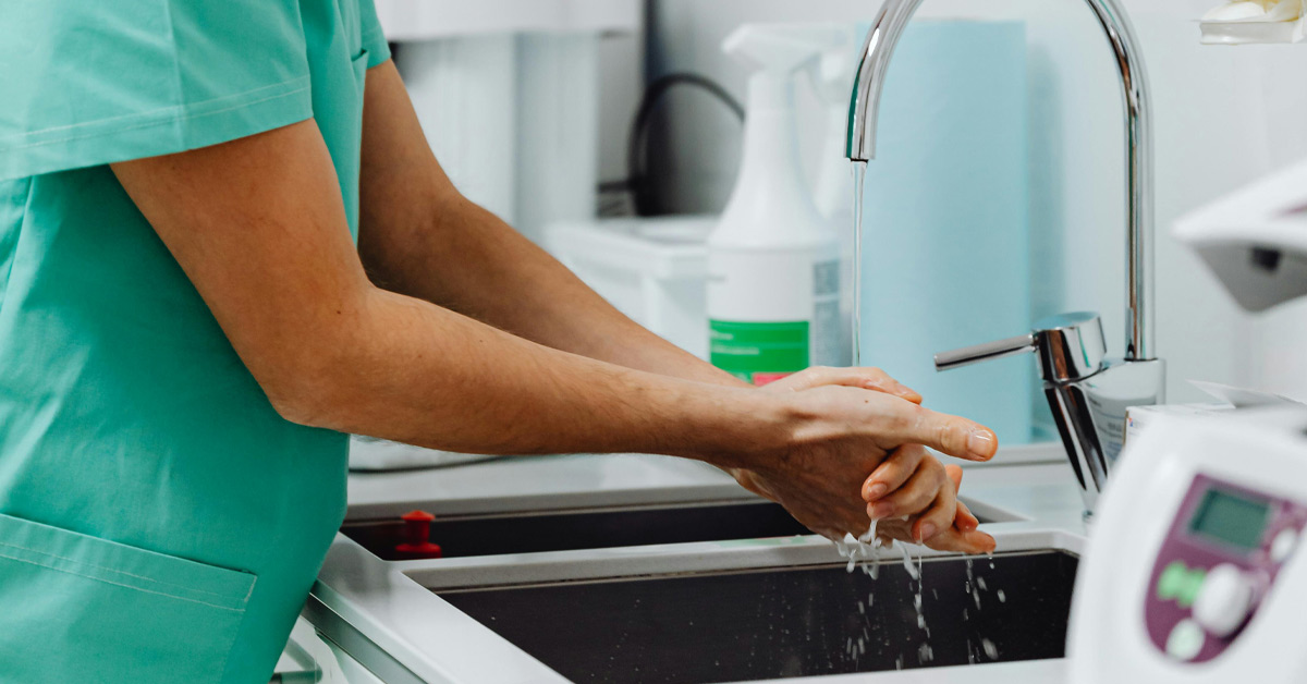 A provider at Payson Walk-In Clinic in Payson, Arizona is washing her hands in a sink while providing primary health care services.